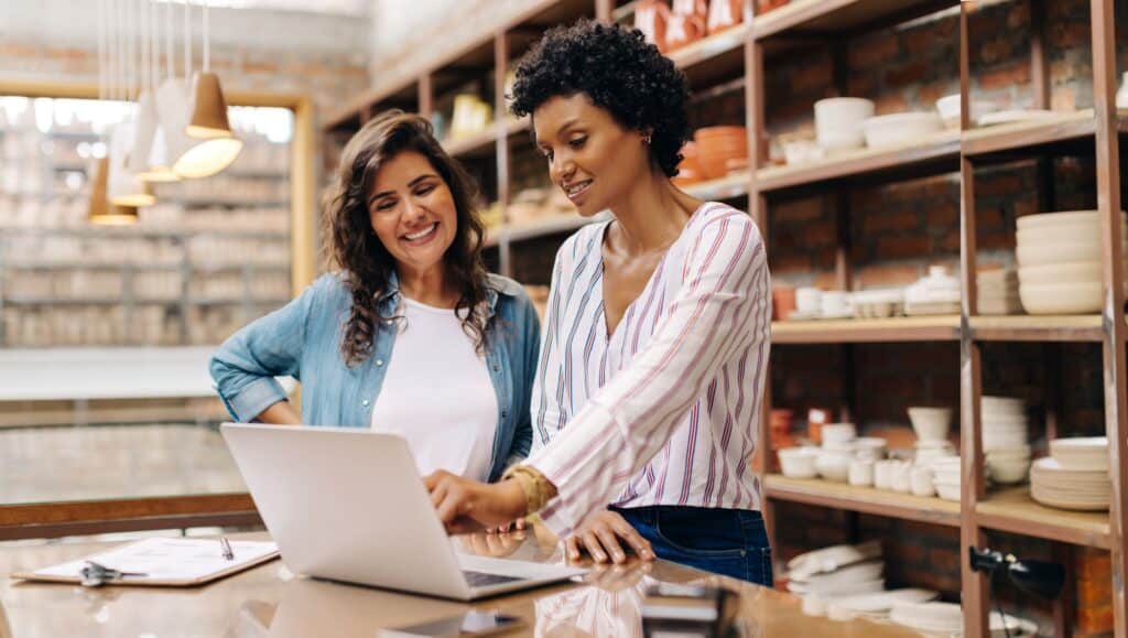 2 women looking at a computer in a pottery shop